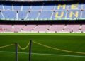 A clear daytime view of Camp Nou Stadium in Barcelona with iconic FCB logo on the field.